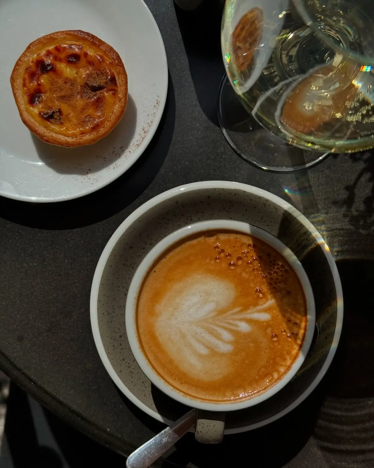 Kawa i świeże pastel de nata na stoliku